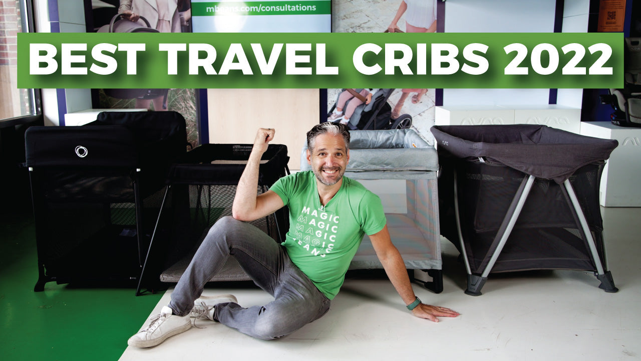 The owner of magic beans sits on the floor smiling. In front of four travel cribs at a store location.