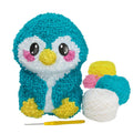 a teal penguin sits with yellow feet and pink cheeks. extra colors of yarn and a hook are surrounding its feet.